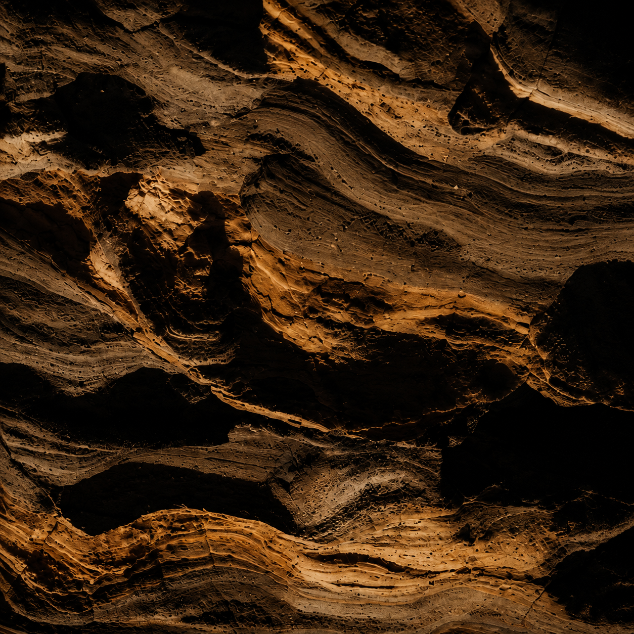 Strati rocciosi sedimentari in tonalità siena e ocra, dettaglio geologico