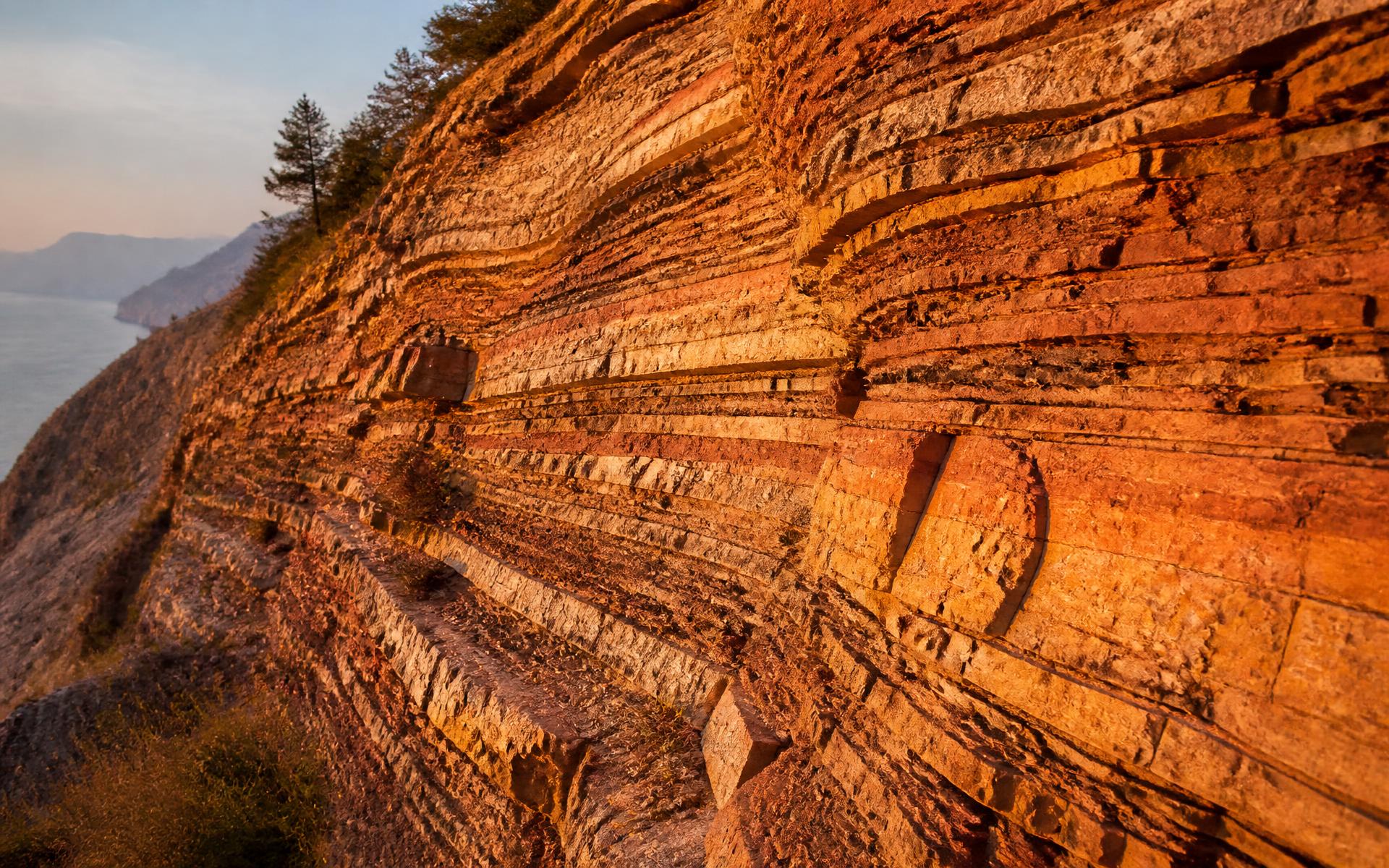 Stratificazioni rocciose sedimentarie illuminate dalla luce calda del tardo pomeriggio